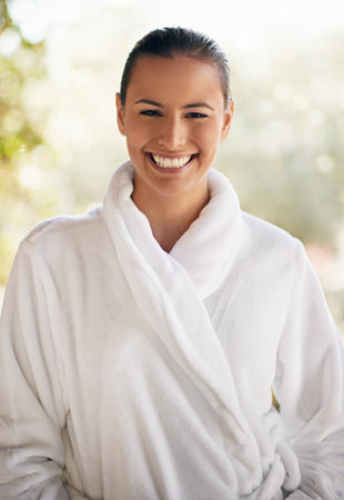 Portrait, smile and woman in hotel, robe and relax in vacation, travel and hospitality in resort in USA. Happy, girl and bokeh in holiday, morning and pride for luxury, break and getaway for personの写真素材