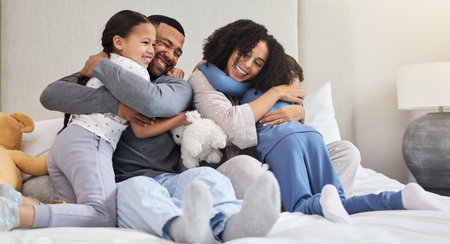 Family, hug and support in home on bed with smile for wellness, relationship and trust in morning. Parents, solidarity and children in bedroom for happy, bonding and relax together as care on weekendの写真素材