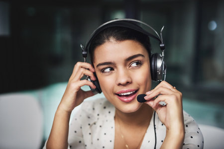 Call center, woman and discussion with headset at night for customer service, help and advice to client. Business, agent and idea with mic at work for IT support, telecom or digital software solutionの写真素材