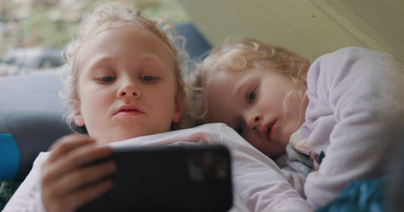 Children, phone and relax for camping outdoor with watching movies, bonding and streaming videos in...