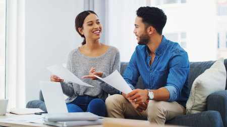 Documents, mortgage and laptop with couple on sofa in living room of home for bank payment. Accounting paperwork, computer or finance with man and woman in apartment to review insurance or taxesの写真素材