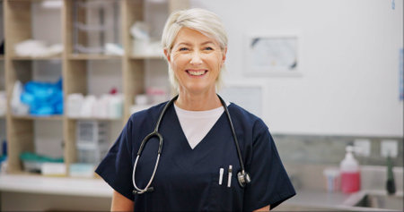 Smile, mature and woman with portrait in vet for professional career in animal care, welfare and wellness. Female veterinarian, pet doctor and specialist with pride for expert support in healthcare.の写真素材