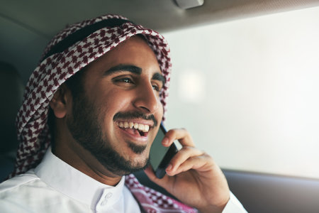 Muslim man, smile and phone call in car for journey, travel or commute in transport. Islam, taxi and passenger talk on mobile for comedy, joke or laugh at funny conversation with contact in backseatの写真素材
