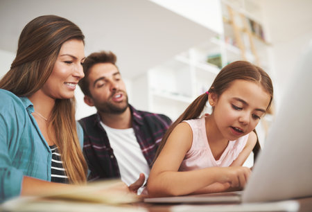 Parents, girl and laptop for homework, typing and helping hand for study, development and online course. Father, mother and daughter by computer, education and e learning with support in family homeの写真素材