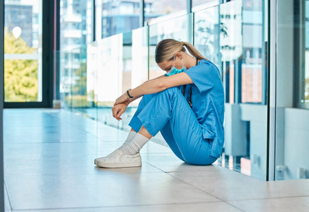 Health, doctor and woman on floor with fatigue for burnout, mistake or surgery fail in hospital. Tired, healthcare and sad female physician with face mask in clinic for stress, medical crisis or lossの写真素材