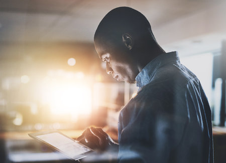 Businessman, research and browsing with tablet for news, planning tasks or schedule at office. Creative man or business employee scrolling on technology for online innovation or startup at workplaceの写真素材