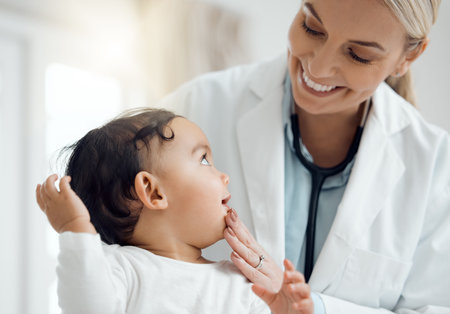 Pediatrician, doctor and baby with consultation, checkup and appointment for wellness, medicare and smile. Professional, infant and kid in office, healthcare and progress with examination and joyfulの写真素材