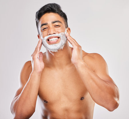 Grooming, man and shaving cream in portrait, routine and wellness in body care, hygiene and white background. Male person, cosmetics and fresh for confidence, masculine and hair removal productの写真素材