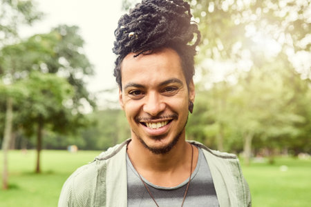 Man, portrait and park with young person happy about nature, travel and freedom. Freelance musician, smile and student busker in New York, countryside and garden relaxing for summer fun and healthの写真素材