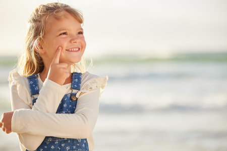Thinking, smile and girl with beach vacation, holiday and view for Miami seaside or getaway trip. Child, outdoor and nature with kid, travel and ocean for summer break with weekend and relaxing wavesの写真素材
