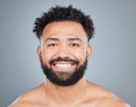 Portrait, happy man and skincare in studio for dermatology, pride and glow from grooming. Male model, wellness and shine or facial by gray background for treatment, results and routine for faceの写真素材