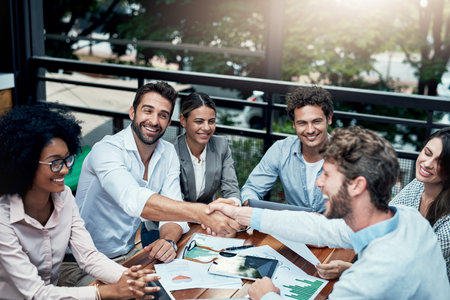 Cafe, business people and handshake for teamwork, agreement and partnership in finance project. B2B, professional career and accountant for collaboration, cooperation and shaking hands by aboveの写真素材