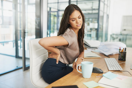 Business, woman and back pain of muscle in office from stress, spine accident and joint injury with medical problem. Female person, massage body and anatomy care, ergonomics and productivity riskの写真素材