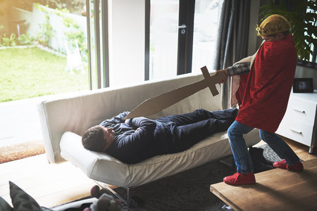 Father, son and playing with sword in costume for cosplay, halloween or dress up at home. Little...