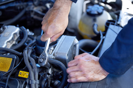 Man, closeup and engine with tools for service in garage, inspection or maintenance on car. Male mechanic, auto and check for problem with oil or motor, technician working with wrench for transportの写真素材
