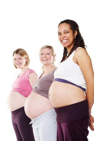 Portrait, women and pregnant in studio for support, wellness and care or love with diversity. Community, friends and happy mothers by white background for development, health and growth for childrenの写真素材