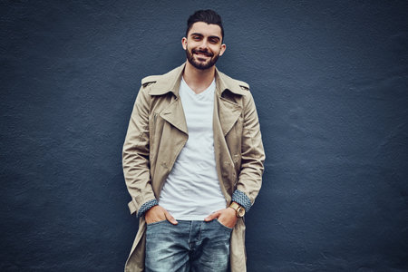 Man, portrait and urban fashion by wall outdoor with streetwear or city style, denim and trendy or stylish clothes. Face, cool and modern designer jeans with capsule wardrobe, mockup and smile.baの写真素材