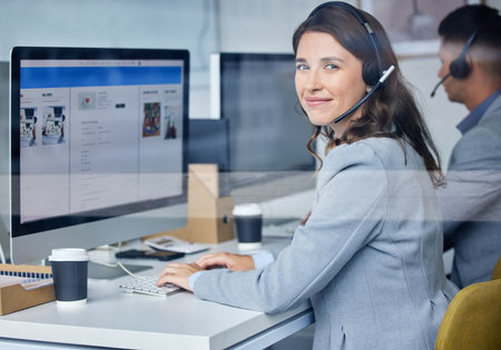 Woman, portrait and call center in office with computer, headset and team for communication with screen. Operator, telemarketing and consultant with customer service for tech support, smile and crm.の写真素材