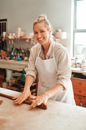 Art, portrait and woman in pottery studio with clay for design, industry or small business startup. Production, retail and smile with professional person in ceramics workshop for hobby or tradeの写真素材