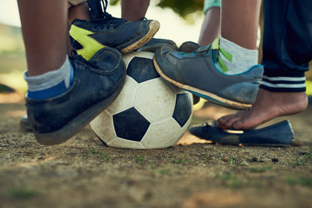 People, legs and soccer ball in sports ground for football match, game and tournament. Outdoor, team mates and training with practice, preparation and fitness for competition on with teamworkの写真素材