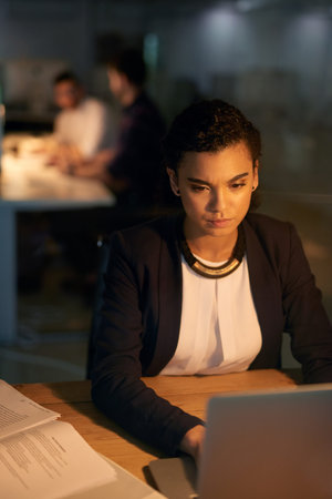 Night, laptop and business woman at desk for project deadline, review or update records. Late,...