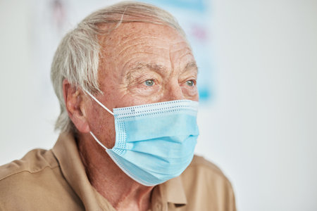 Old man, face mask and sick protection in epidemic or healthcare consultation in clinic, compliance or safety. Male person, ppe and hospital for infection prevention or senior, hygiene or contagiousの写真素材