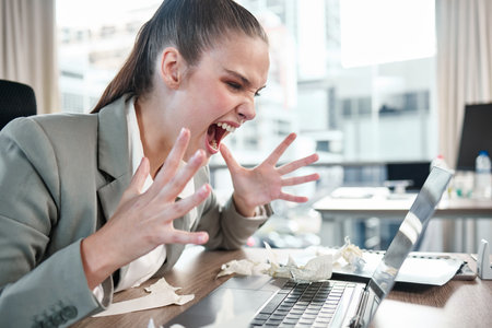 Angry, business woman and scream at computer from stress, burnout and frustration at company report. Female person, hands and shouting at tech with glitch in office for panic at proposal deadlineの写真素材