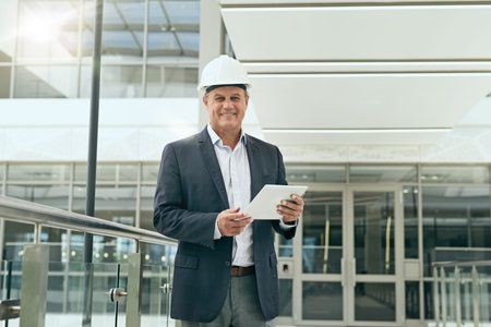 Portrait, business and man with tablet, architecture and smile with urban planning, digital app and hard hat. Face, person and expert with tech, helmet and specialist with inspection and engineeringの写真素材
