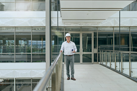 Blueprint, engineer and portrait of happy man at construction site for office renovation. Helmet,...