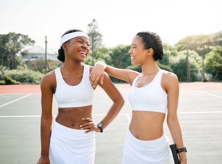 Tennis, happy and women on court for sports, training and workout for practice, competition and match. Fitness, friends and people smile for bonding, exercise and winning for playing games togetherの写真素材