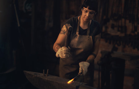 Welding, confident and woman with steel, workshop and proud of gender equality in foundry and blacksmith. Hardworking, apron and manufacturing in factory, person and skills for welder and darkの写真素材