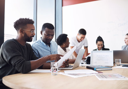 Business people, discussion or documents in meeting for teamwork, report or collaboration in startup. Planning, graduation certificate and marketing graduate speaking of feedback or project paperworkの写真素材