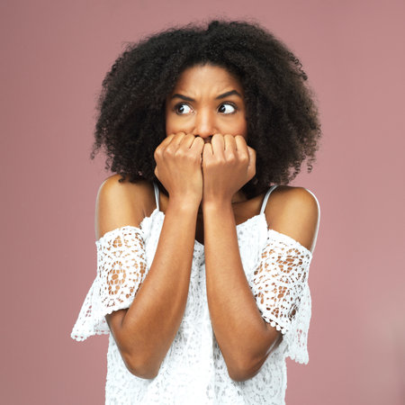 Anxiety, nervous and scared woman in studio with mistake, stress and overthinking trauma or crisis on color background. Doubt, risk and girl model with fear emoji for worry or overwhelmed by disasterの写真素材