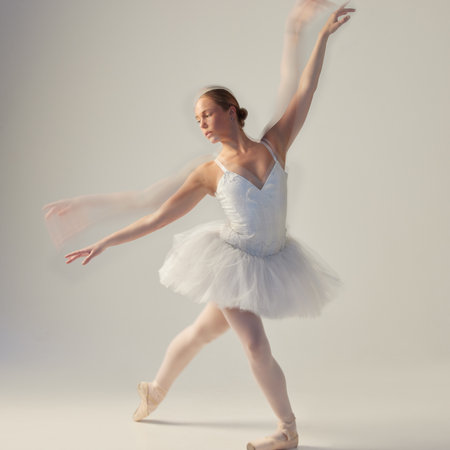 Ballet, dance and woman with motion blur in studio for performance art, routine and movement. Creative, skill and ballerina with stretching for flexibility, freedom and technique on white backgroundの写真素材