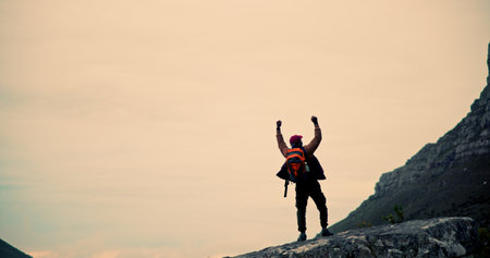 Man, hiker and success with mountain in nature, body exercise and adventure for wellness or cardio activity. Sky, fitness and backpack person outdoor, challenge and achievement or horizon for winの写真素材