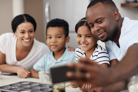 Happy family, baking and selfie with ingredients in kitchen for morning, bonding or love together at home. Mother, father and young children with smile for picture, photography or memory for cookingの写真素材