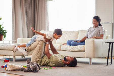Home, parents and child with airplane on floor for balance, freedom and bonding together in childhood. Happy, father and son with game by toys in living room for love, care and imagination of flightの写真素材