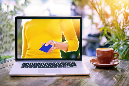 Laptop, screen and hand with credit card in cafe for ecommerce payment for sale, discount or promo. Person, pay and online shopping offer on website or booking travel with banking info or financeの写真素材