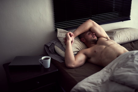 Man, sleeping and morning in bed, calm and lazy on weekend or comfortable in bedroom apartment. Male person, dreaming and tired to resting or relax in home, shirtless and fatigue for nap wellnessの写真素材