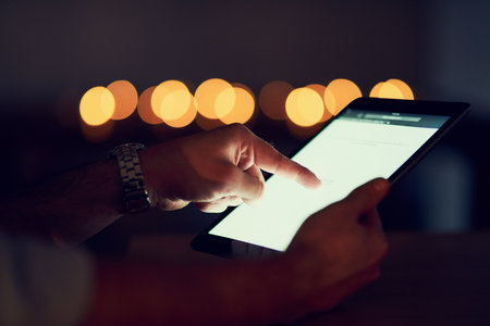 Hands, tablet and person browsing in the dark for communication at night on travel app or website. Technology, social media and evening with email for copywriter business , research and work in Spainの写真素材