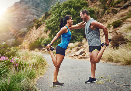 Couple, stretching and together on mountain for fitness, warmup and commitment to wellness. Man, woman and training in nature for health, wellbeing and fresh air for work out, cardio or enduranceの写真素材