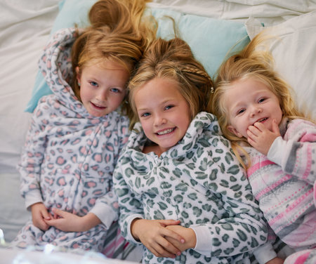 Portrait, children and sisters in bedroom for love, family and together in home on weekend. Smile, girls and siblings at night for relax, sleeping and happiness in winter for holiday in Europe