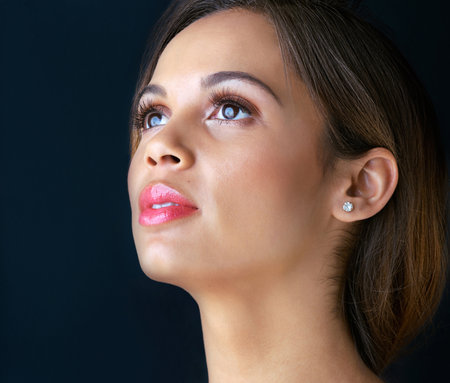 Beauty, thinking and woman in studio with makeup, confidence and healthy skin glow. Skincare, dermatology and proud face of girl with luxury cosmetics, inspiration and facial shine on blue backgroundの写真素材