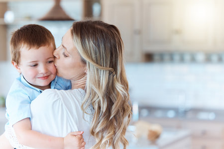 Smile, young boy and mother with kiss, happiness and bonding as family in home for growth or child development. Cheerful toddler, woman and together for kid as parents with love, affection or careの写真素材