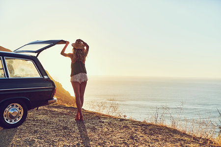 Journey, view and woman with ocean, car and adventure with getaway trip, travel and beach. Nature, person and girl with vehicle, transportation and seaside with break, holiday and explore in Baliの写真素材