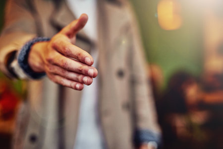 Closeup, handshake and man with greeting, cafe and welcome with agreement, introduction and thank you. Person, shaking hands or guy in restaurant, hello and friendly with trust, polite or cooperationの写真素材