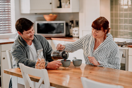 Relationship, couple and coffee in kitchen for romance, love and bonding together on weekend. Breakfast, man and woman sharing morning drink in home with smile for connection, comfort and cute momentの写真素材