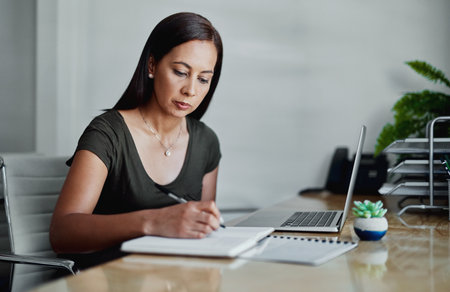 Office, laptop and business woman with notebook for writing, to do list and planning for daily tasks. Workspace, computer and female journalist with journal for interview questions, topic or thinkingの写真素材