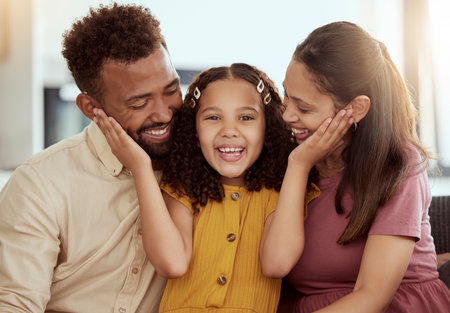 Portrait, young girl and parents for love, support and childcare with trust, together and happy in bonding. Affection, woman and daughter with man in embrace, connection and comfort as family in homeの写真素材