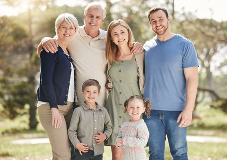 Happy, nature and portrait of family generations at outdoor park with connection on holiday. Smile, hugging and children siblings with grandparents and parents in field on vacation in California.の写真素材